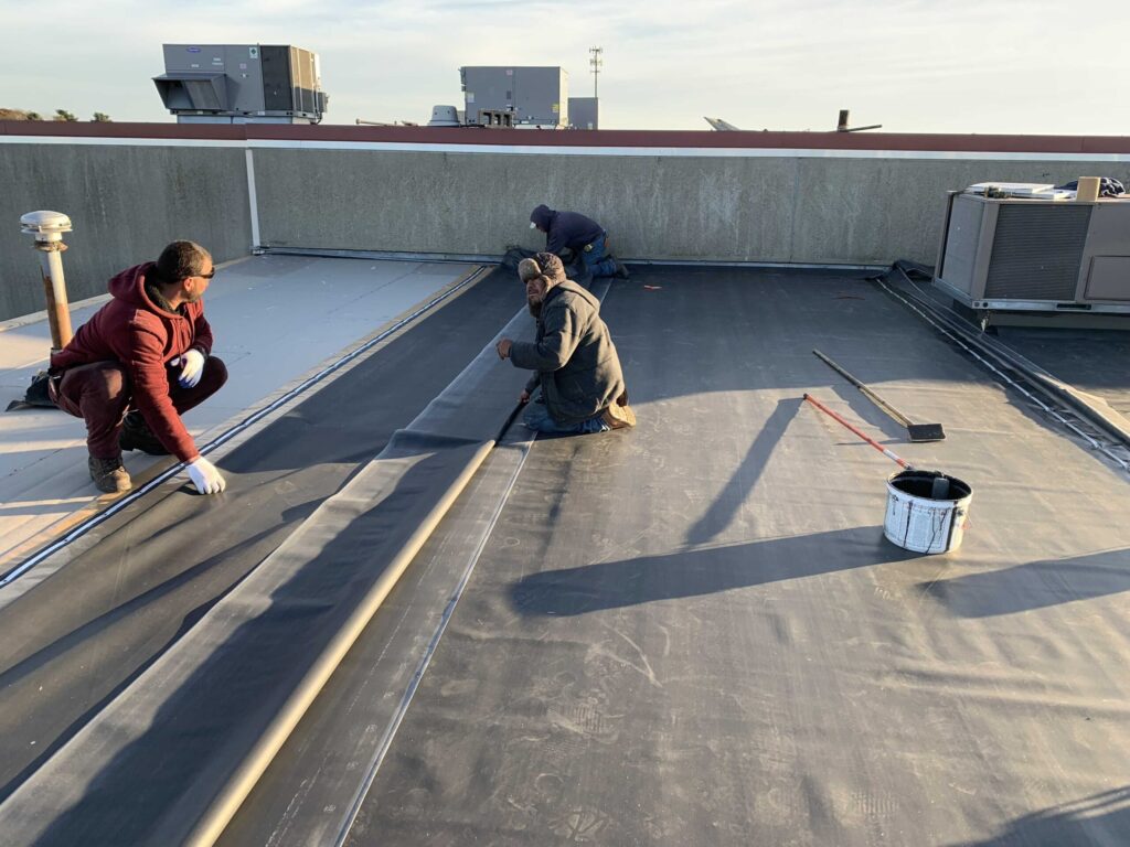 Roofing team installing a commercial membrane system